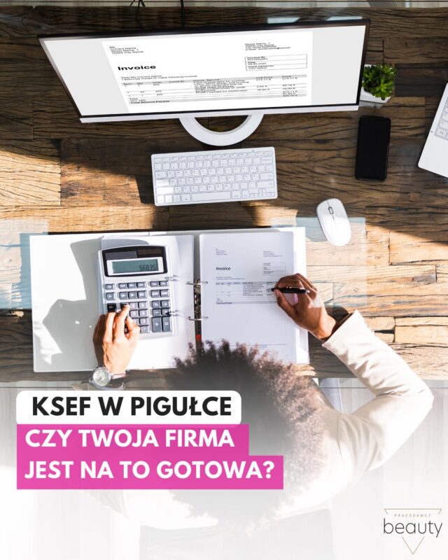 Mężczyzna siedzi przy komputerze z góry, trzyma notes, arkusz kalkulacyjny i długopis